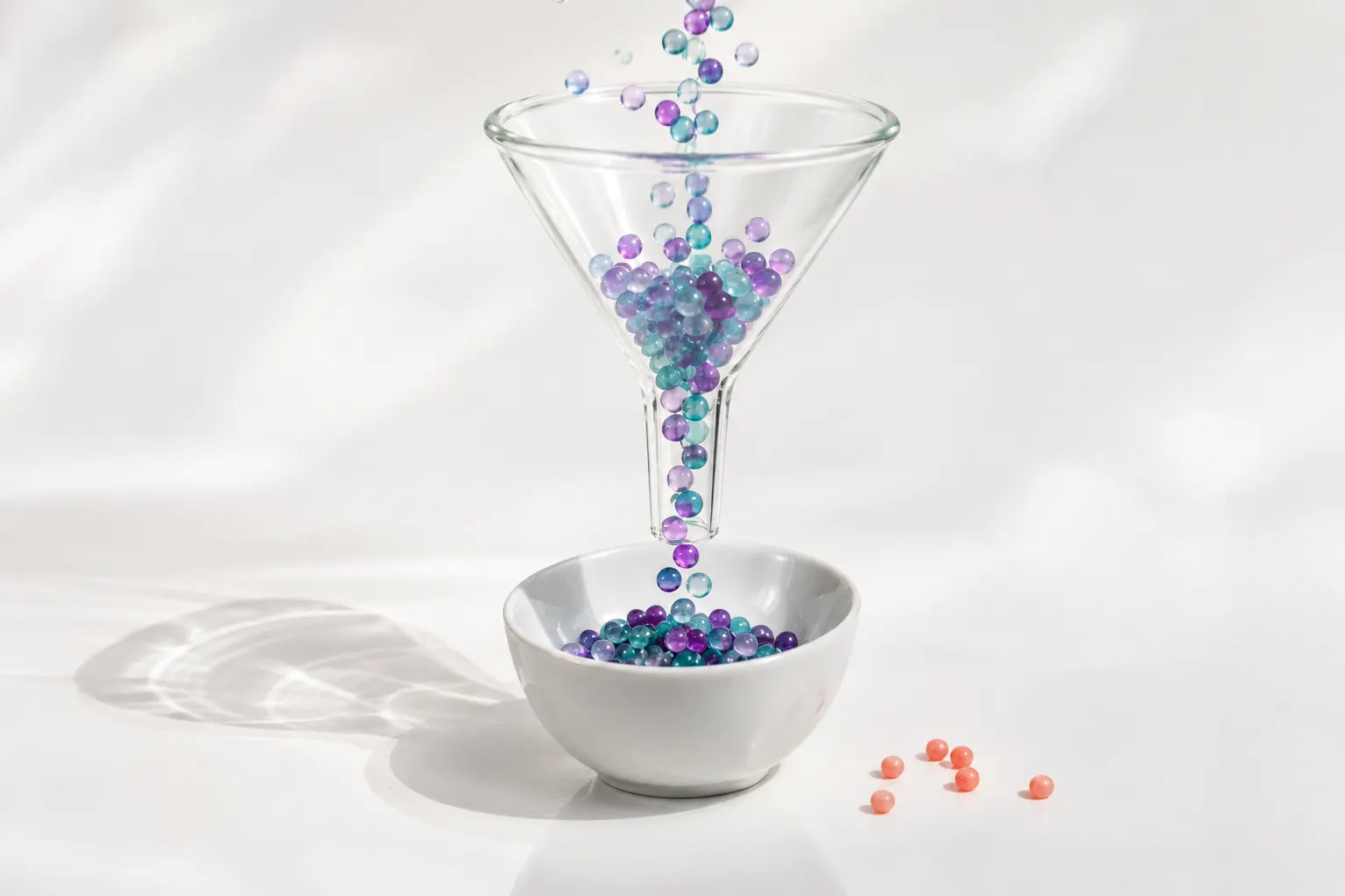 Entonnoir en verre traversé de perles colorées, image des conversions SEO suivies dans GA4